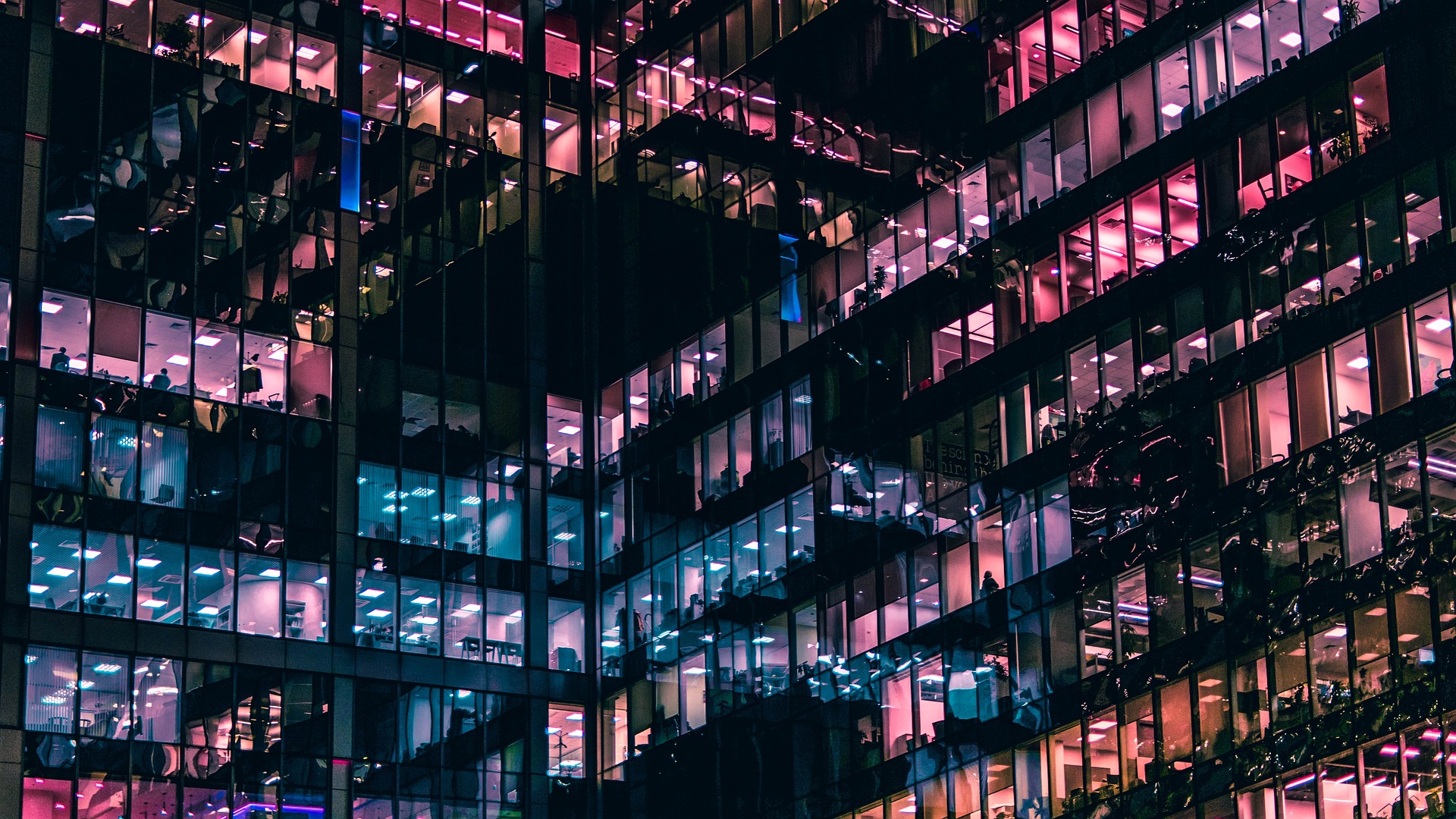 City windows at night in shades of purple, blue, and peach